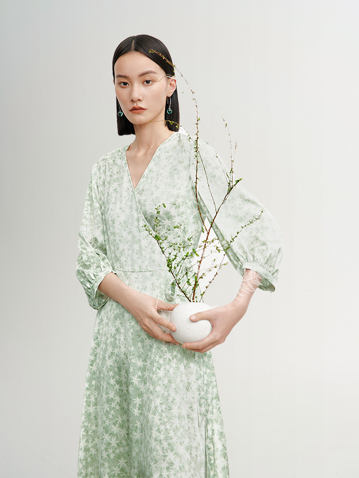 Mint green floral print dress with a v-neck, crossover cut and an irregular hem
