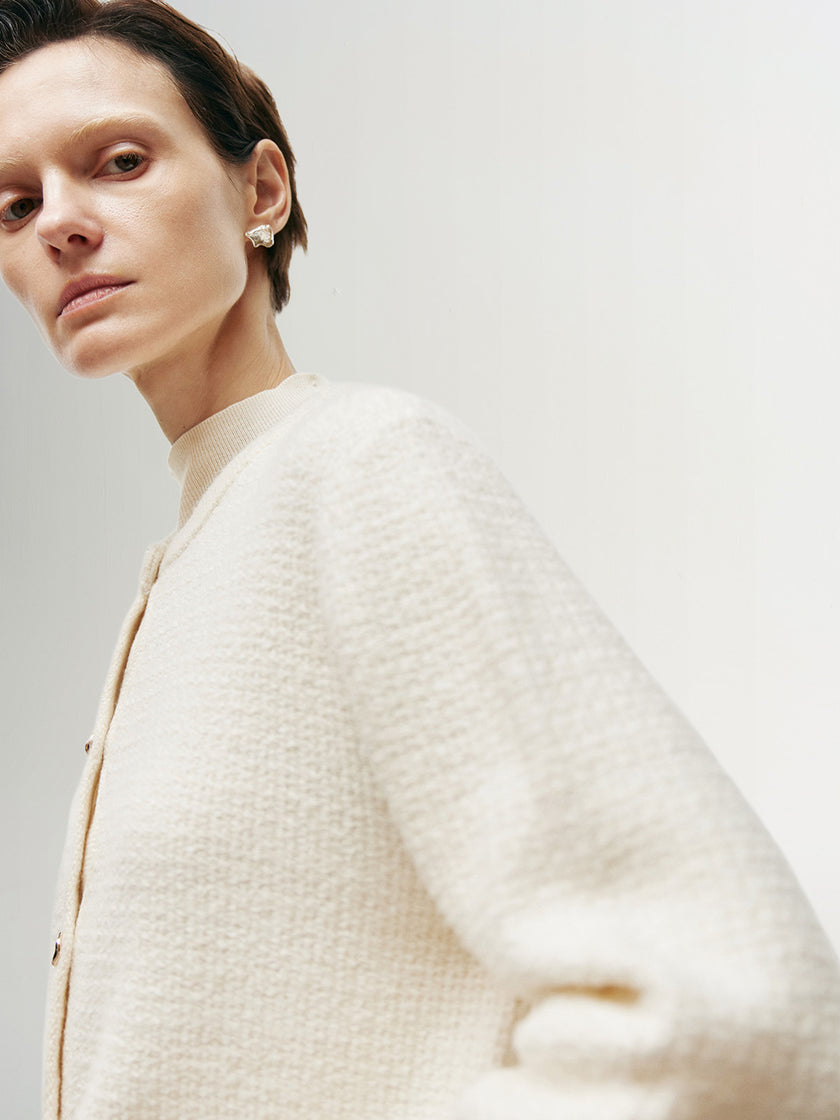 White knitted sweater with round neck and long sleeves