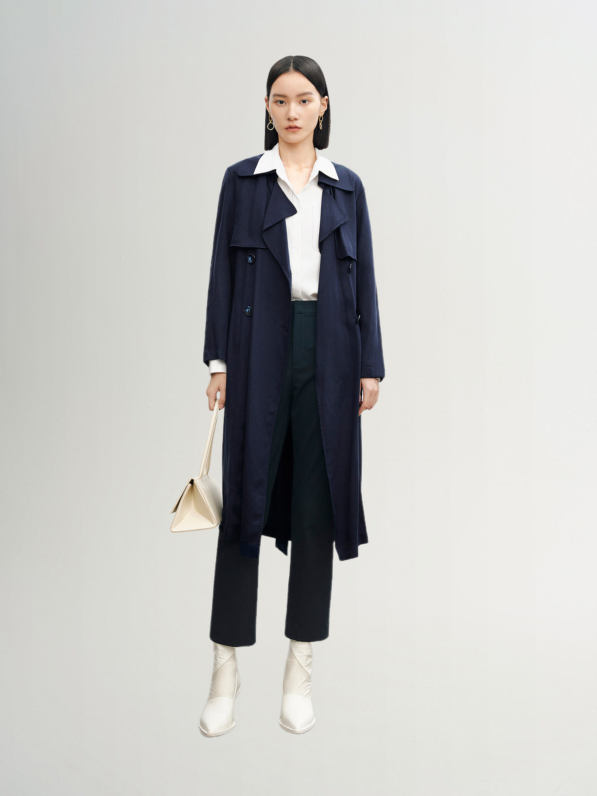 Navy blue mid-length trench coat with button fastening and belt
