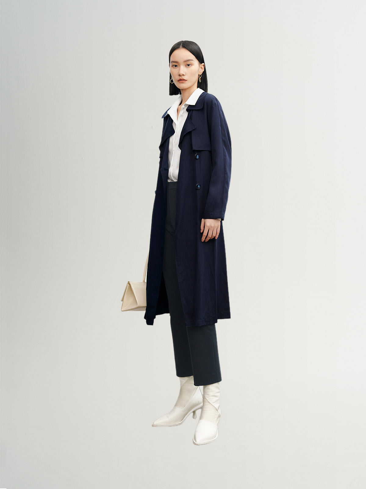 Navy blue mid-length trench coat with button fastening and belt