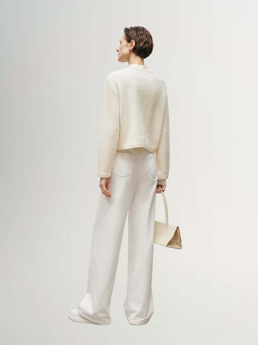 White knitted sweater with round neck and long sleeves