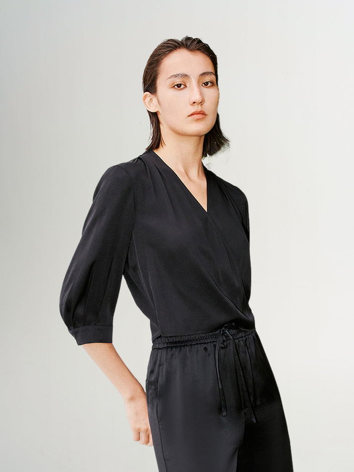 Blouse noire en soie à col en V et style croisé