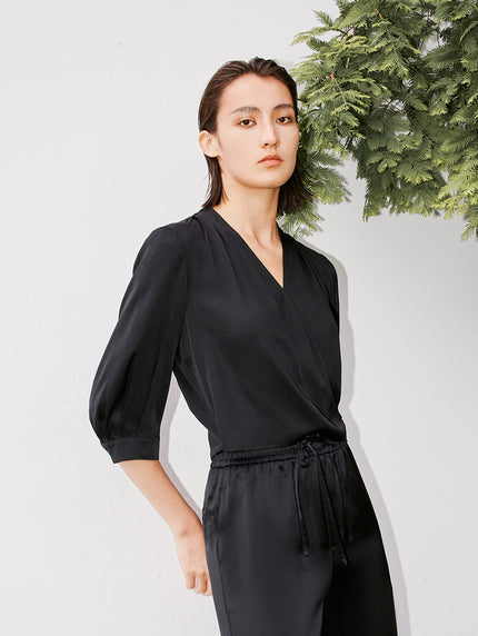 Blouse noire en soie à col en V et style croisé