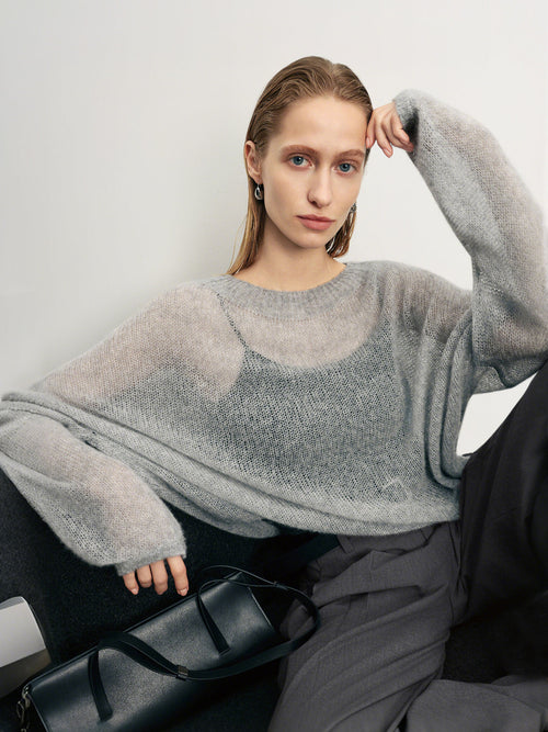 Charger l'image 1 dans la galerie. Woman wearing a gray sweater sitting on a black chair against a white background