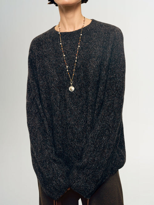 Charger l'image 1 dans la galerie. Person wearing a dark gray sweater and a long necklace with a pendant on a light gray background