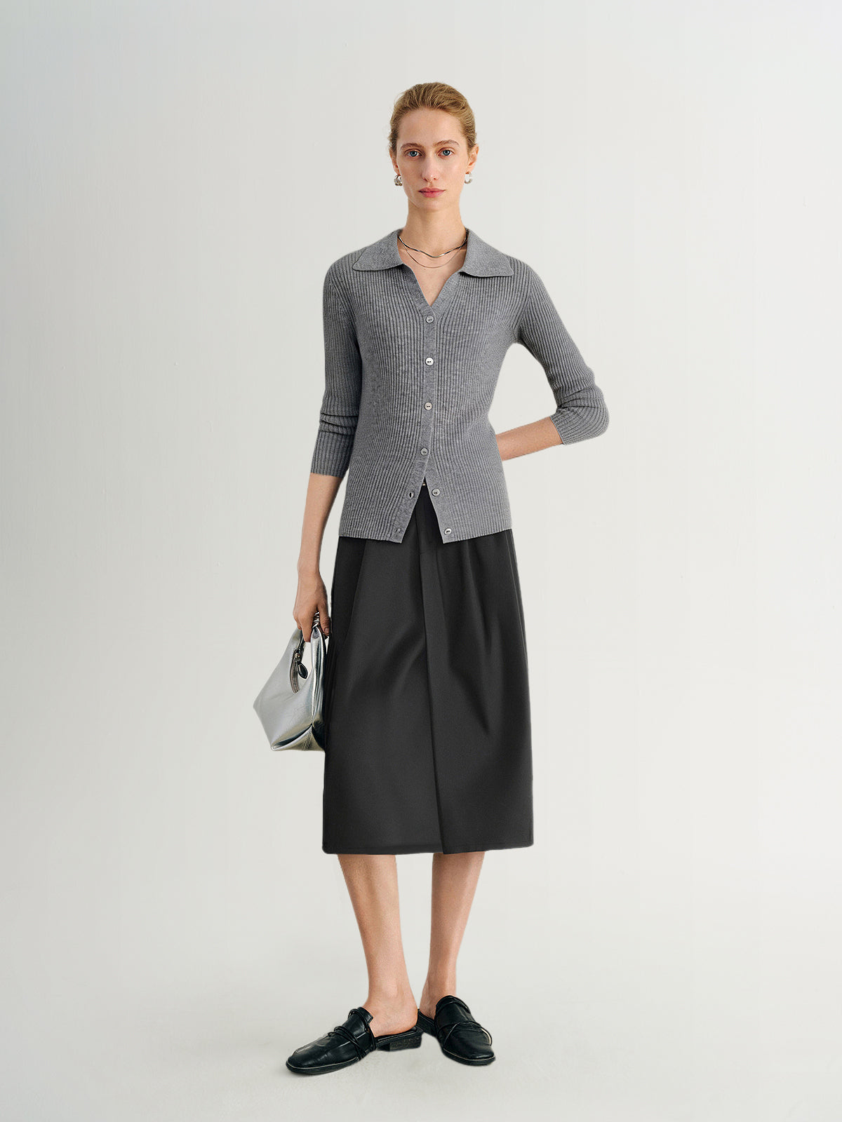 Woman wearing a gray checkered shirt and black skirt on a white background