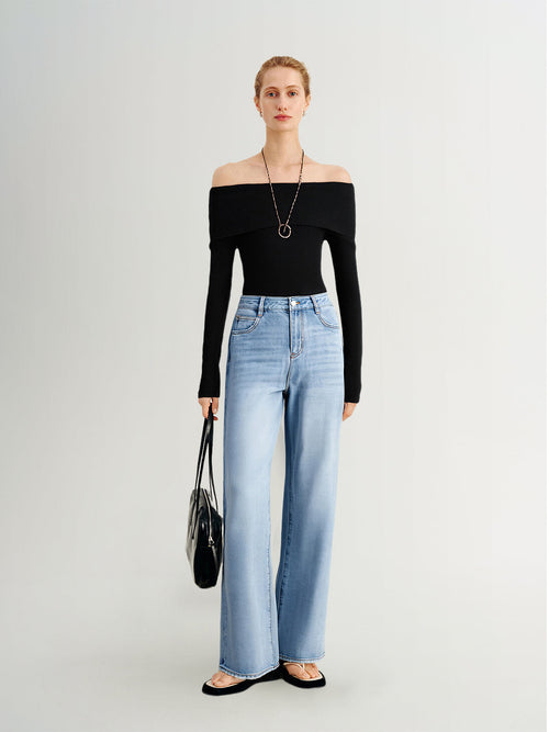 Load image 1 in gallery view. Woman wearing a black off-shoulder top and light blue jeans on a white background