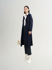 Navy blue mid-length trench coat with button fastening and belt
