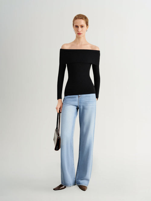 Load image 1 in gallery view. Woman wearing a black off-shoulder top and light blue jeans on a white background