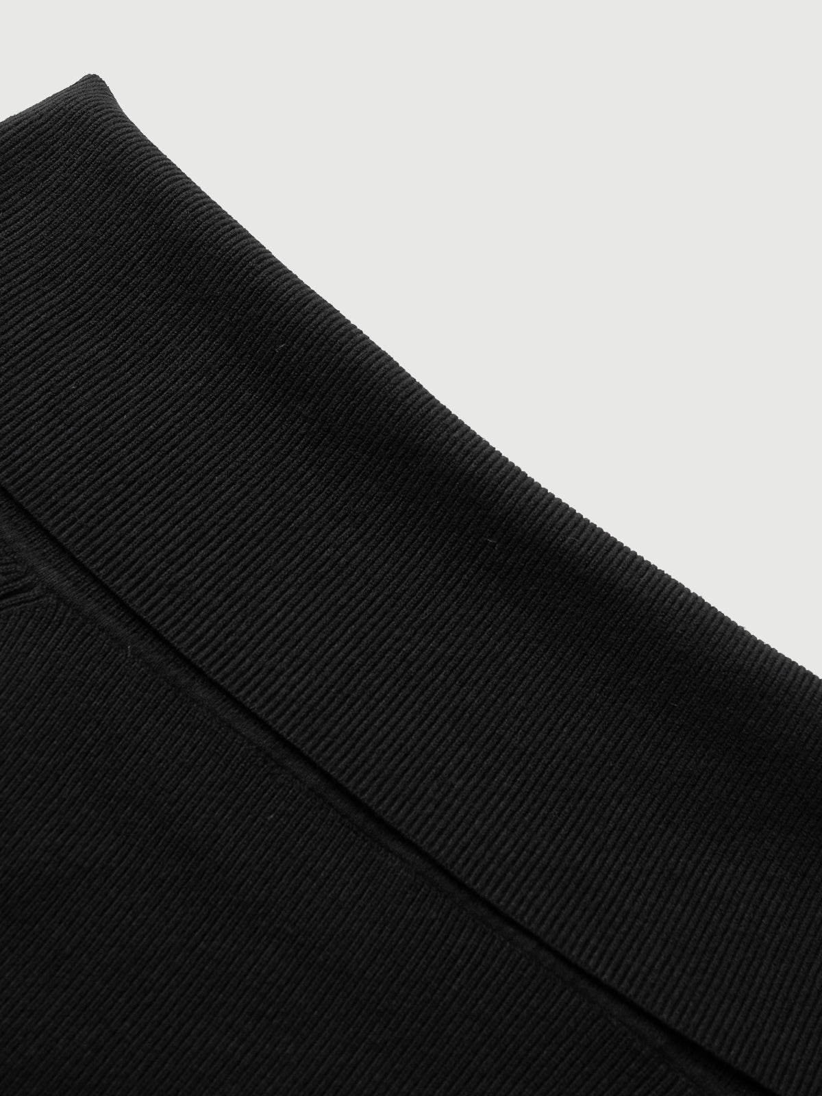 Close-up of a black fabric texture on a light gray background