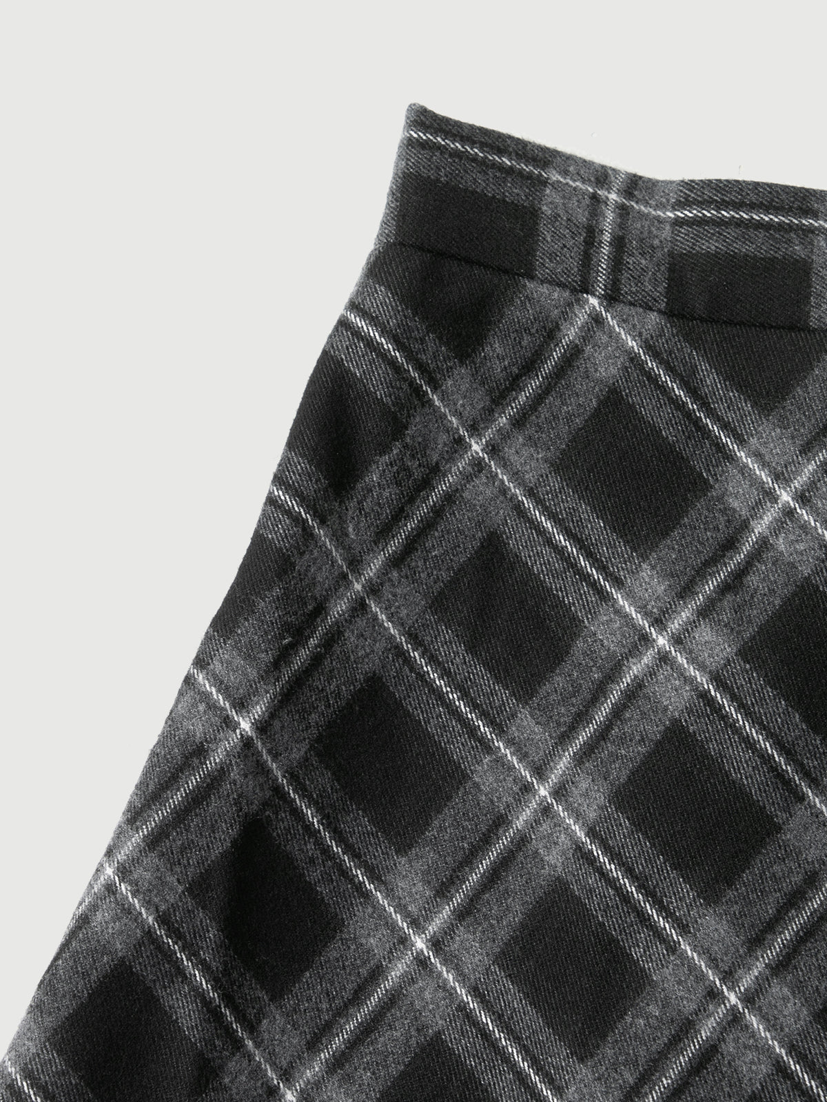 Close-up of a black and gray plaid pattern on a plain background